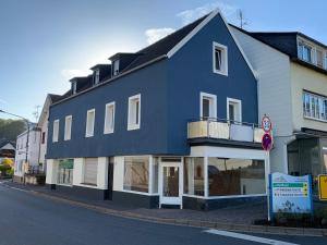 een blauw-wit gebouw aan de straatkant bij Ferienwohnung Kylltal in Birresborn