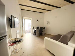 Una sala de estar con un sofá y un comedor. en Il Trogolo, en Matera