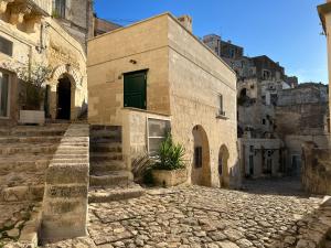 un edificio de ladrillo con una puerta verde en una calle en Il Trogolo, en Matera