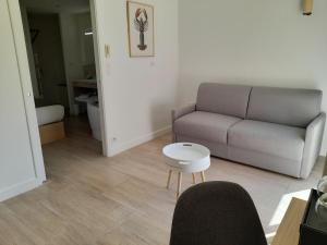 a living room with a couch and a table at Hôtel L'Albatros in Saint-Trojan-les-Bains