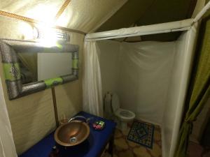 a small bathroom with a sink and a toilet at Merzouga Activities Camp in Merzouga +56 photos