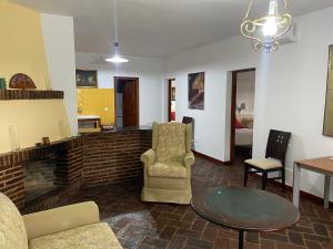a living room with a fireplace and chairs and a table at Casas Rurales Monasterio de Rocamador in Almendral