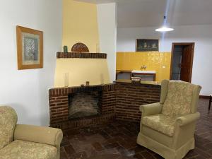 a living room with two chairs and a fireplace at Casas Rurales Monasterio de Rocamador in Almendral