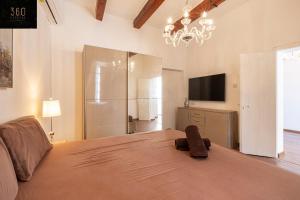 a bedroom with a large bed with a chandelier at Palazzo 16th Century Mdina, opposite St Paul's Cathedral by 360 Estates in Mdina