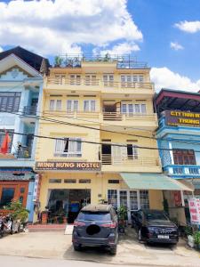 a yellow building with a car parked in front of it at Minh Hưng Hostel in Sa Pa