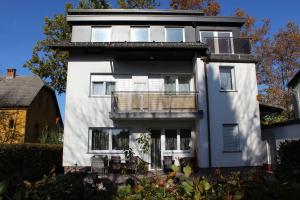 ein weißes Haus mit Balkon darüber in der Unterkunft Apartma Jaka in Ljubljana