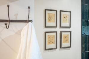 un asciugamano appeso a una parete con quattro quadri incorniciati di Tipple Cottage a Peasenhall Altre 23 foto