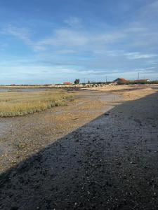 una larga sombra de un camino al costado de un campo en L'étoile de mer, en Bourcefranc