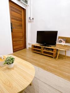 a living room with a television and a table at Lively and cozy canal house ,Entire house in Bangkok