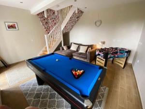 a living room with a pool table and a couch at Glaisters Farmhouse in Castle Douglas
