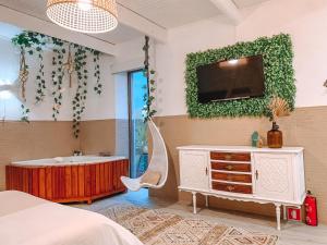 een slaapkamer met een bad en een tv aan de muur bij Douro Rural Suite in Porto