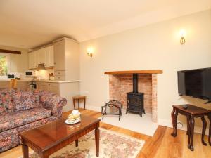 a living room with a couch and a fireplace at Mill Cottage in Upwey