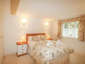 a bedroom with a bed and a window at Mill Cottage in Upwey