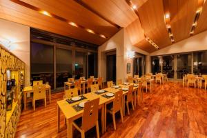 a dining room with wooden tables and chairs at 151 Hakuba by Jade Group in Hakuba