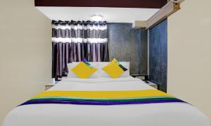 a bedroom with a white bed with colorful pillows at Amber Corp Inn, Near Nesco Exhibition Center in Mumbai