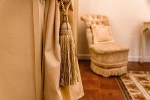 a broom hanging from a door in a room with a chair at B&B Palazzo Cerami in Catania