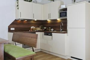 una cocina con armarios blancos y fregadero en s'Landhaus, en Neustift im Stubaital
