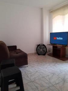 sala de estar con sofá y TV en APARTAMENTO MEDELLIN, en Medellín