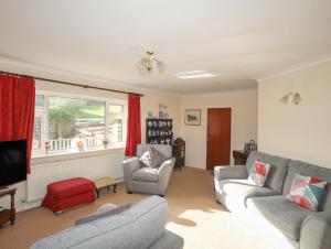 a living room with two couches and a tv at 14 Cae Pin in Pwllheli