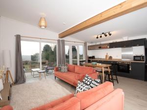 a living room with orange furniture and a kitchen at Murmur y Coed in Llanfairpwllgwyngyll