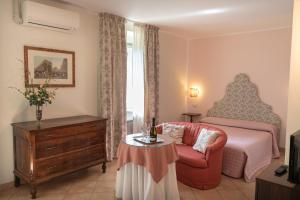 a bedroom with a bed and a chair and a table at Hotel Umbra in Assisi