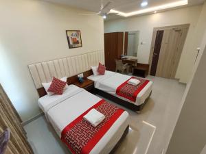 a hotel room with two beds and a table at Sri Aswin Grand in Nāmakkal