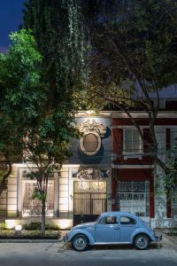 Niebieski samochód zaparkowany przed domem w obiekcie Roso Guest House w mieście Meksyk