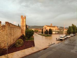 a flooded street with cars parked next to a brick wall at Ca L'Aida Rural 2 in Montblanc