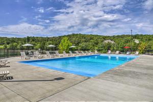 a large swimming pool with chairs and umbrellas at Branson West Retreat - 2 Mi to Silver Dollar City! in Branson West