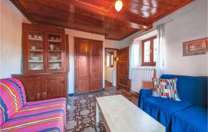 a living room with a blue couch and a table at Holiday Home Via Colle I in Cardoso