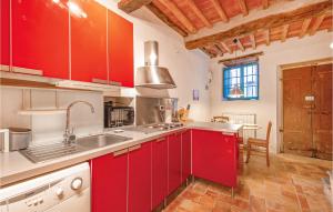 a large kitchen with red cabinets and a sink at Holiday Home Via Colle I in Cardoso