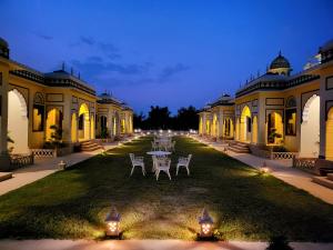 een herenhuis met een tafel en stoelen in de tuin bij The Grand Barso (A Luxury Heritage) in Bharatpur