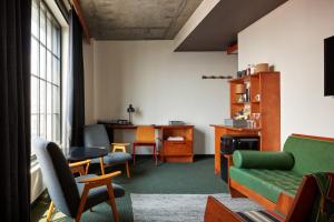 een woonkamer met een groene bank en stoelen bij Ace Hotel Brooklyn in Brooklyn