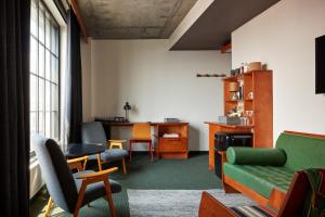 a living room with a green couch and chairs at Ace Hotel Brooklyn in Brooklyn
