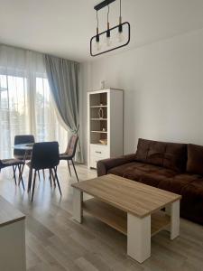 - un salon avec un canapé et une table dans l'établissement Divany Apartament, à Braşov