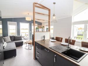 a kitchen with a sink and a living room at The Gallops in Chipping Norton