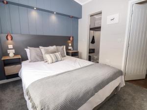 a bedroom with a large bed with a blue wall at The Gallops in Chipping Norton