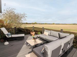a patio with a couch and a table and chairs at The Gallops in Chipping Norton