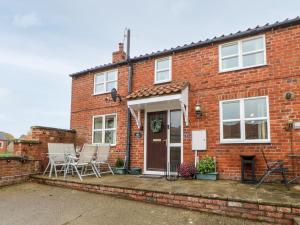 a red brick house with chairs and a porch at 1 Wildsmith Court in York