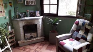 a living room with a fireplace and a chair at Sitio Aguá Santa in Itapeva