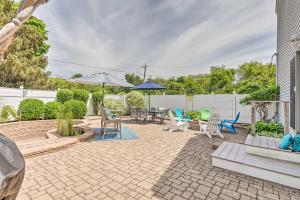 a patio with chairs and tables and umbrellas at South Kingstown Vacation Rental 2 Mi to Beach! in South Kingstown
