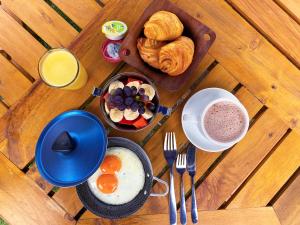 a table with breakfast foods and a bowl of eggs and bread at Hotel Evoque Sáchica in Villa de Leyva