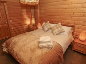 a bedroom with a bed with two towels on it at Leafy Hollow Lodge in Louth