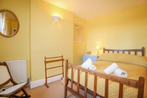 a bedroom with a bed and a chair and a mirror at Bay View in Swanage