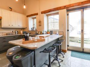 a kitchen with a large island with stools in it at Mosscarr Barn in Harrogate