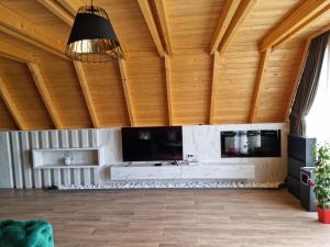 a living room with a fireplace and a wooden ceiling at Batllava Premium Resort Villa 7 in Orllan