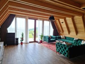 a living room with green furniture and large windows at Batllava Premium Resort Villa 7 in Orllan