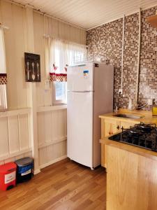 a kitchen with a white refrigerator and a stove at Quintal das Araucárias hospedagem in São Joaquim