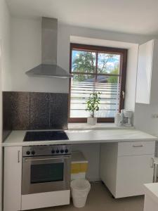 a white kitchen with a stove and a window at GoldStar Apartments nähe Messe in Sarstedt