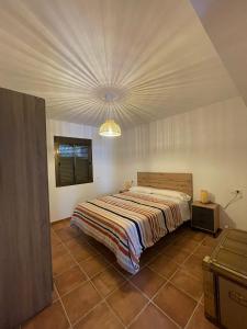 a bedroom with a bed in a room with a ceiling at La Casa del Muro in El Bosque